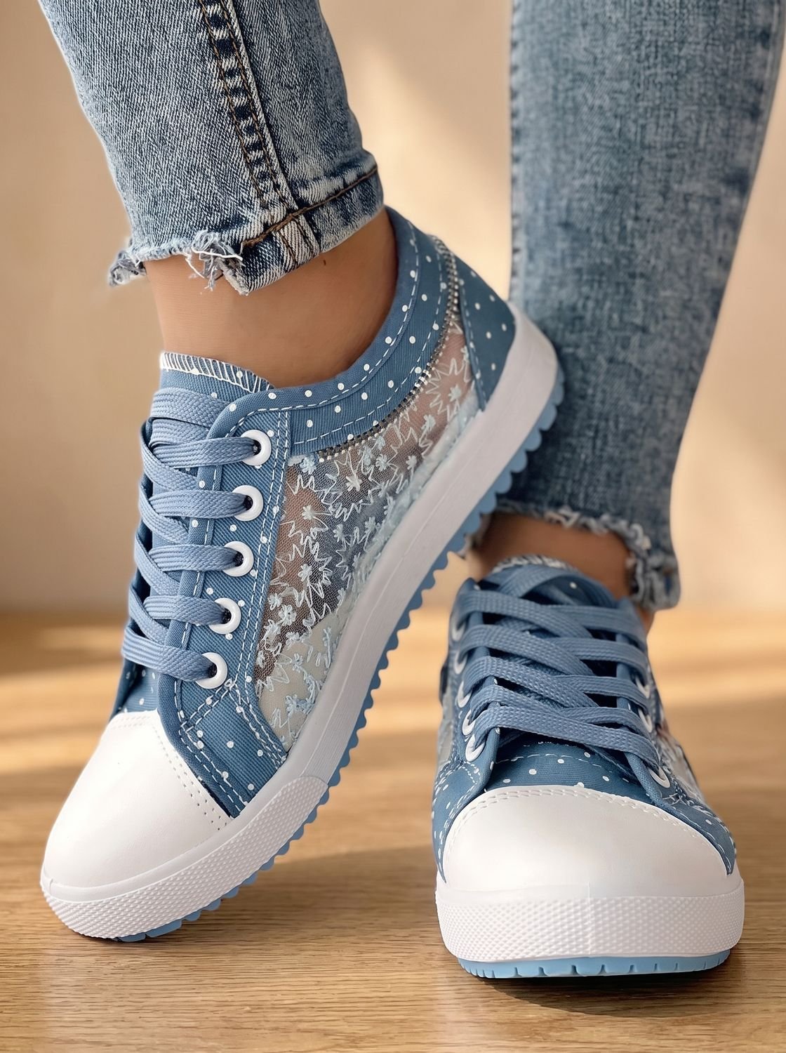 Vista lateral de zapatilla ortopédica con cremallera decorativa y dije floral